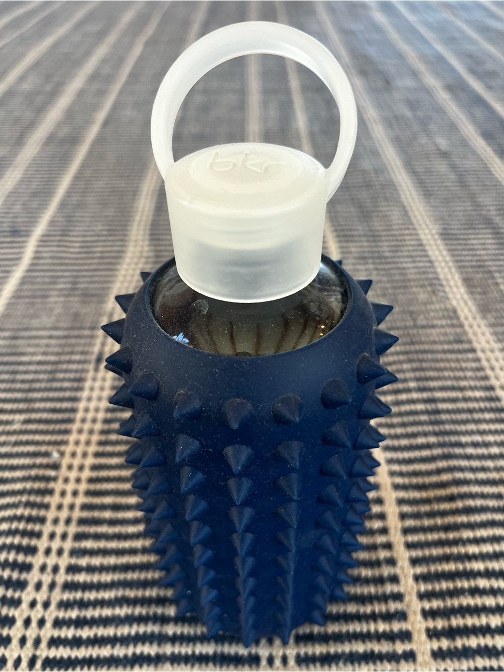 Bkr spiked sleeve glass water bottle in navy or Fifth Avenue in little 16 oz